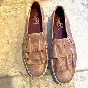 Keds ladies sneakers. Size 8 in a pink rose gold metallic luck. NWOT Slip on’s